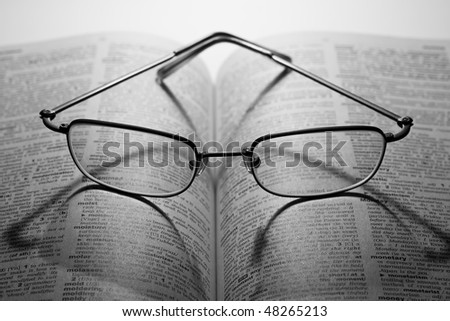 Glasses on the book on the white background