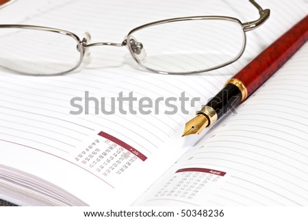 Daily planner with glasses and pen