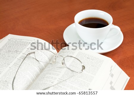 work place table with book, glasses and coffee cup