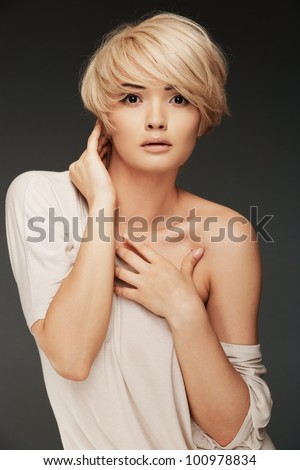Young woman portrait. Closeup beauty studio shoot. Healthy clean skin and perfect makeup on beautiful face of white model with short blonde hair. Beautiful girl.