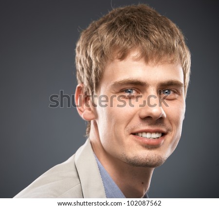 New generation young smiling businessman, studio isolated portrait on gray background