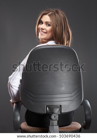 Beautiful business woman [ bank employee ] portrait sitting in chair back turned. Relaxing smiling female office worker