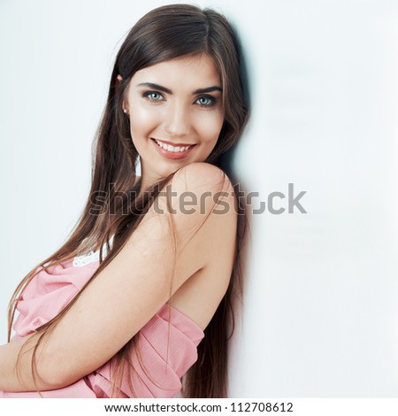 Beautiful woman standing by the side of the white wall. Close up portrait.