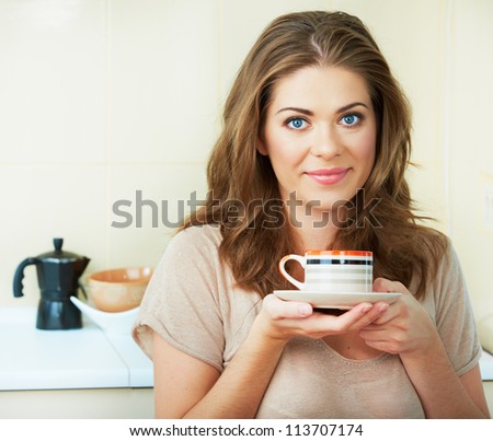 Portrait of smiling  woman holding coffee cup at the kitchen interior. Close up smiling female face.