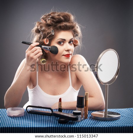 Portrait of a young woman with long hair . Smile happy girl seating at table with make up accessories and mirror