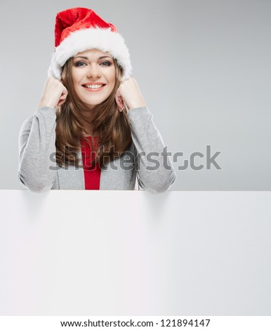 Christmas Santa hat woman portrait. Female smiling model hold white blank board.Young woman  on gray background isolated