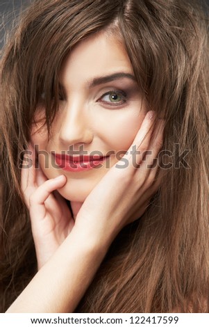 Close up portrait of beautiful young woman face with long hair. Isolated on gray background. Portrait of a female model.