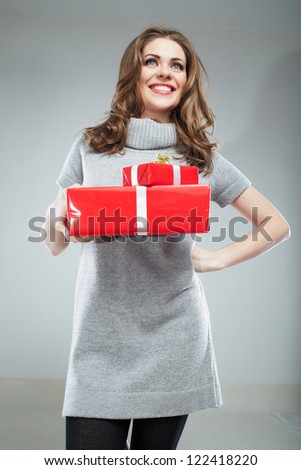 Gift box woman hold against gray background. Isolated portrait of young smiling model.