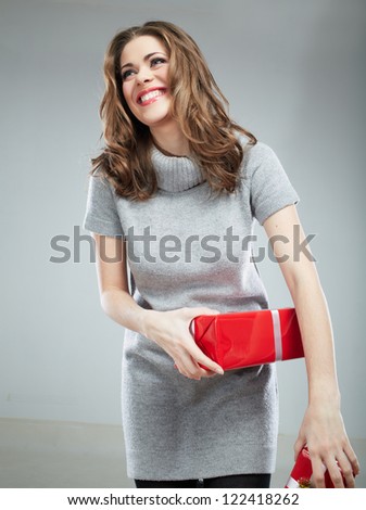 Gift box woman hold against gray background. Isolated portrait of young smiling model.