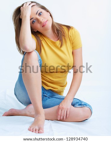 Portrait of smiling young woman seating on floor isolated on white background