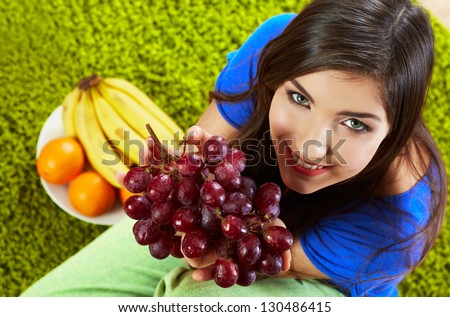 Woman seating on floor with fruits. Female model indoor portrait.