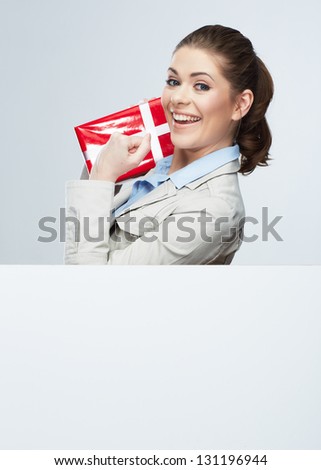 Corporate bonus concept . Smile Business woman hold red gift box, portrait with blank white board on gray isolated . Female smiling model .
