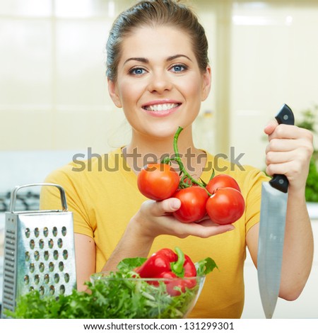 Happy Woman prepare  vegetarian food,  standing against  home kitchen interior background. Yellow color clothes. Woman Face close up portrait.