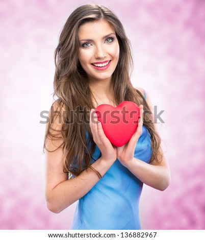 Happy smile woman holding red heart. Female model hold valentine day symbol. Pink background.
