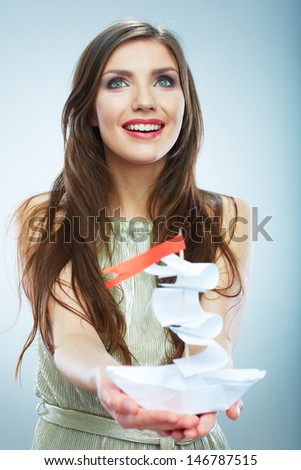 Portrait of young smiling woman hold white paper ship. Female model isolated studio portrait.