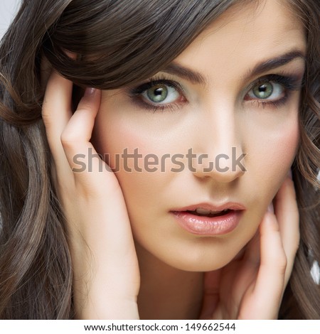 Woman beautiful face portrait. Skin care style face hand touching. Female model studio posing.