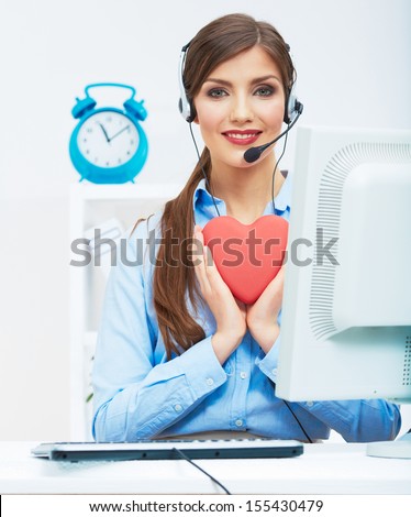 Portrait of call center smiling operator with phone headset isolated on white office background hold red heart. Help concept.