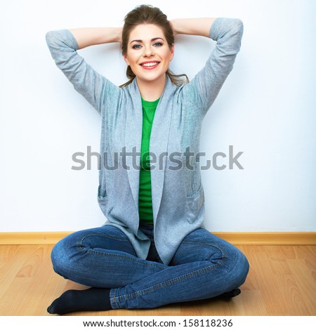 Woman natural portrait seatting on a floor. White background isolated. Smiling girl.