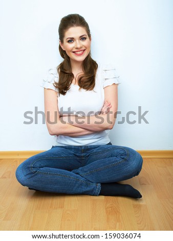 Woman natural portrait seating on a floor. White background isolated. Smiling girl.