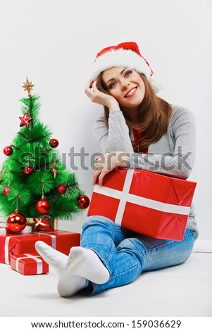 Christmas santa woman with christmas gift. Isolated smiling woman in santa hat.