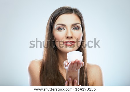 Woman hold cosmetic cream. Beautiful face young model. Isolated portrait.