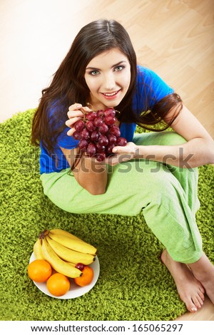 Woman diet food. Model seat on a floor. Fruit diet.