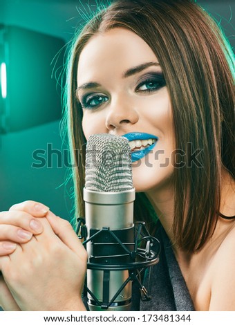 Singing star. Woman singer portrait. Sound studio.