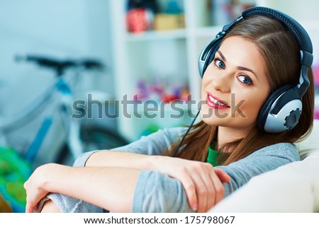 Smiling woman listening music in headphones. Young woman model.