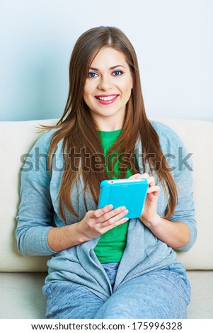Smiling woman on sofa with tablet pc. Young smiling model portrait.