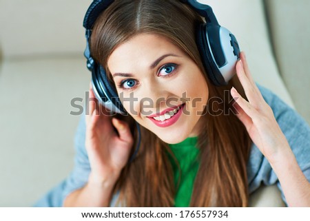 Smiling woman listening music in headphones. Young woman model.