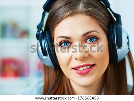 Girl with headphones listening music at home. Female model.