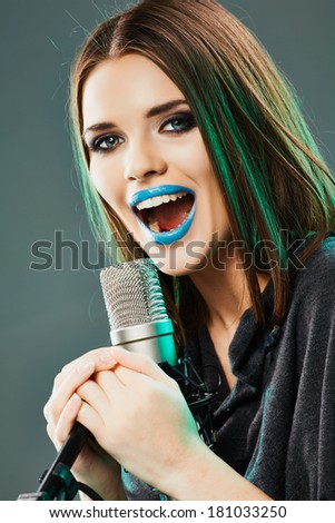 Girl singing into a microphone. Studio sound records.