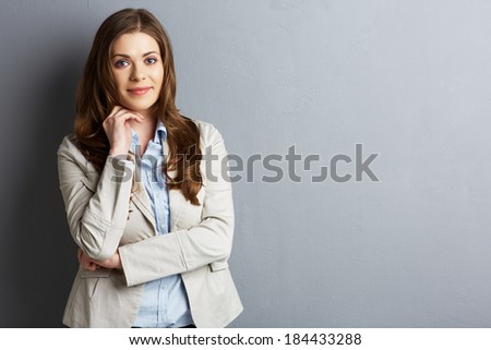 Smiling business woman portrait. Standing against wall.