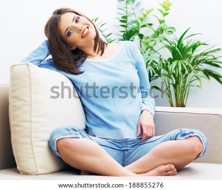 Woman sitting on sofa in yoga pose. Home exercise.
