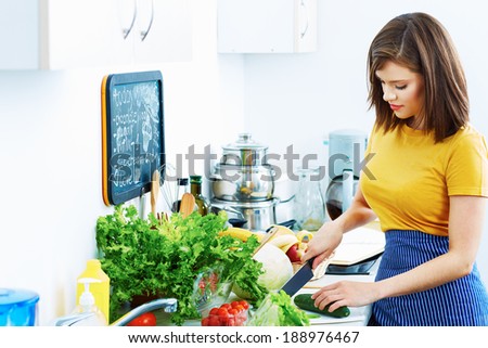 Smiling woman cooking at home kitchen. Beautiful woman chef.