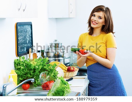 Young woman cooking vegetable in kitchen. Green diet.