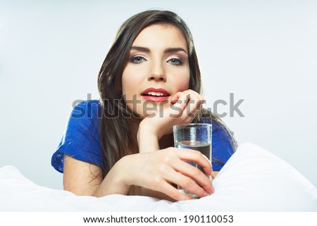 Woman in bed hold water glass. Smiling girl.