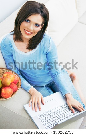 Woman sitting on sofa using laptop. Woman working at home.