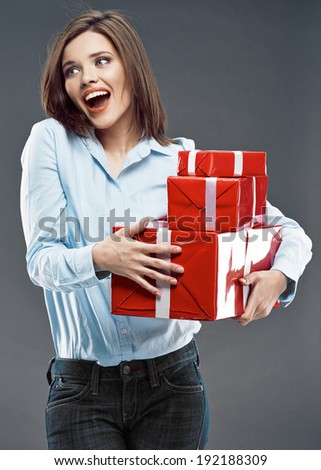 Surprised business woman hold red gift. Studio isolated on gray background.