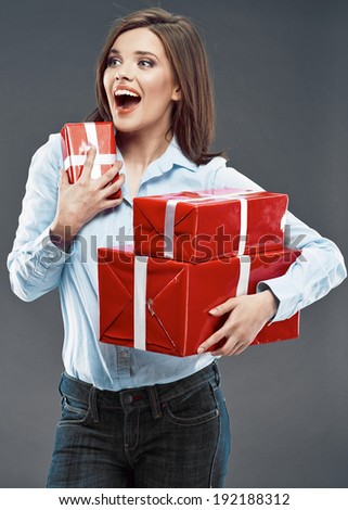 Surprised business woman hold red gift. Studio isolated on gray background.