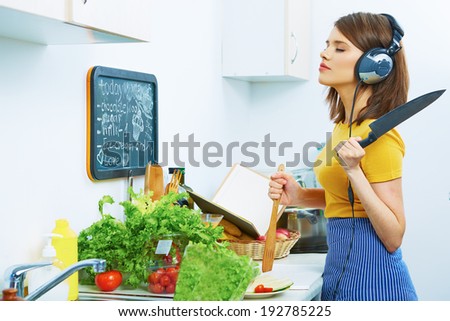 Beautiful woman cooking in kitchen and listen music. Cooking with fun.