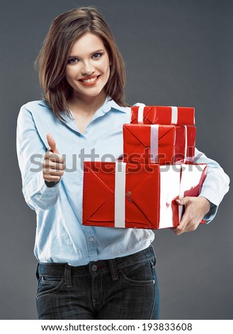 Smiling business woman hold red gift box show thumb up. Studio isolated.