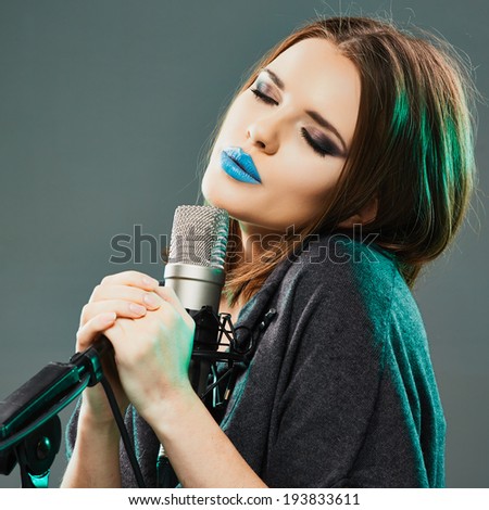 Beautiful woman with microphone. Long hair, blue lips.