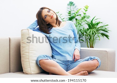 Smiling woman sitting on sofa. Indoor portrait.