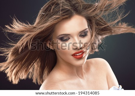 Young beauty model with blowing hair. Studio isolated portrait.
