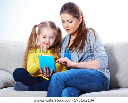Mother with daughter sitting on sofa home work learning. Family portrait.