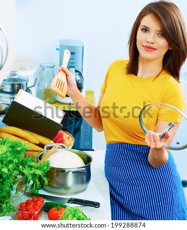 Cooking woman in kitchen with wooden spoon. Organic breakfast prepare.