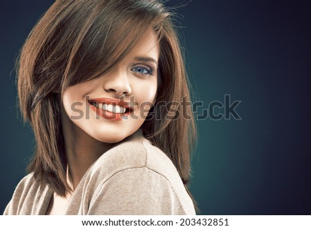 Woman beauty face against dark studio background. Close up