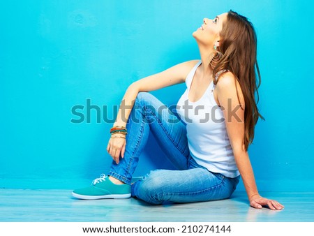 dreaming woman looking up, sitting on a floor . full body portrait