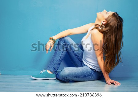 dreaming woman looking up, sitting on a floor . full body portrait